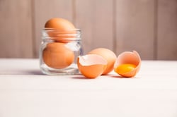 Eggs in a jar by broken egg shells on the table-1