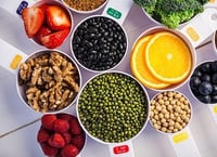 Portion cups and spoons of healthy ingredients on wooden table