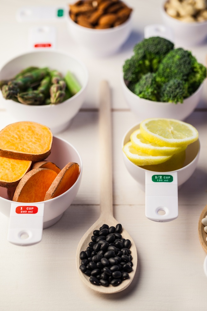 Portion cups of healthy ingredients on wooden table