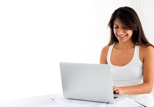 Woman working on a laptop and looking happy