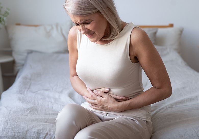 woman with stomach pain on bed